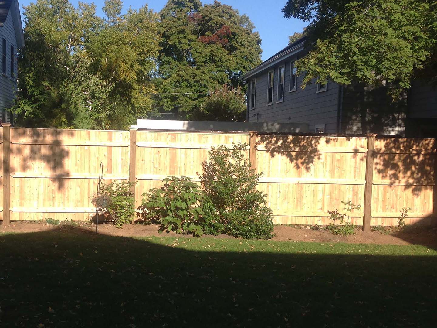 Stockade wood fence along a property line, Merrimack Valley MA